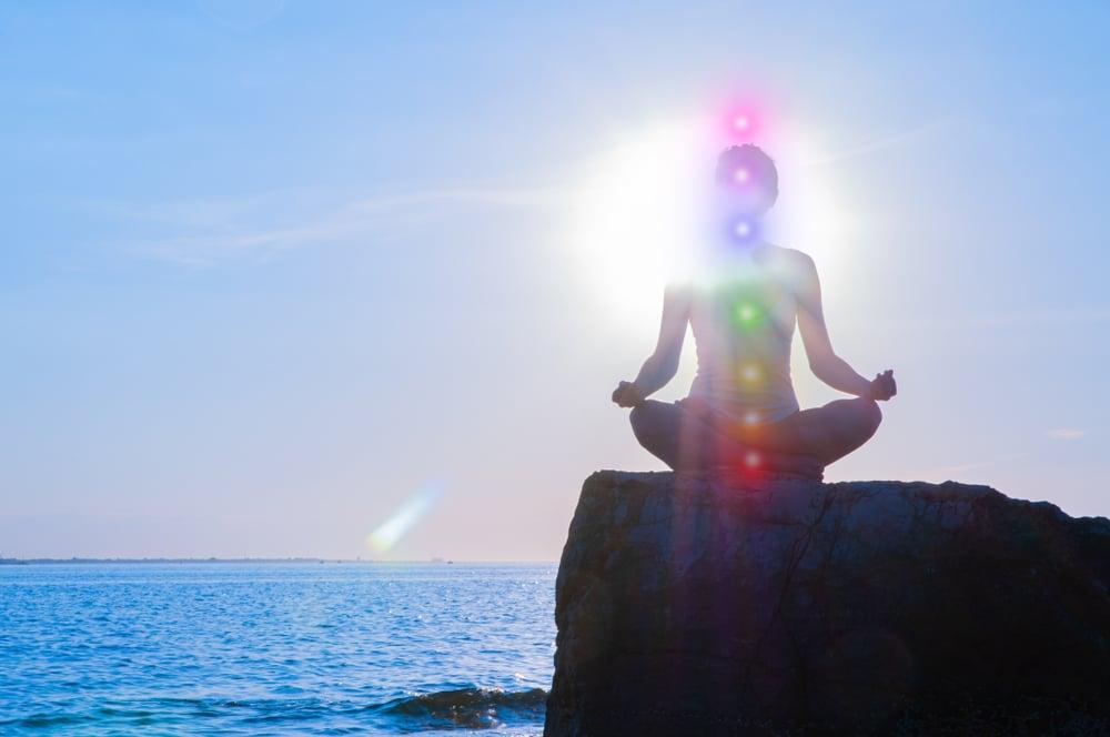 Woman,Is,Meditating,With,Glowing,Seven,Chakras,On,Stone,At